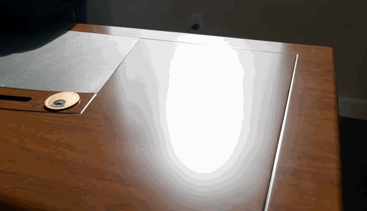 Sunlight glaring off a wood desk surface near a window, illustrating the need for commercial window tint to block excess light.