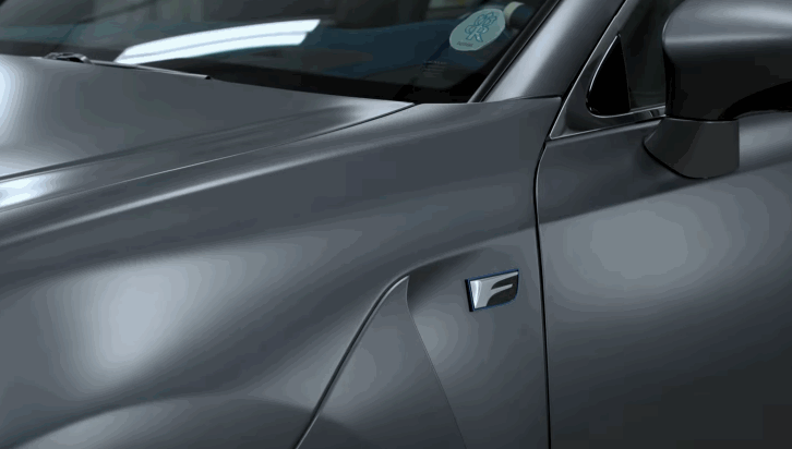 Close up of a gray car door and front fender with a smooth satin finish that shows the clean surface after ceramic coating. The paint reflects soft shop lighting across the body lines and side mirror.